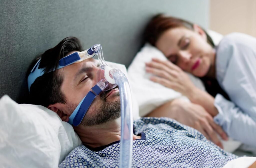 A person with sleep apnea sleeps peacefully while wearing a CPAP mask.