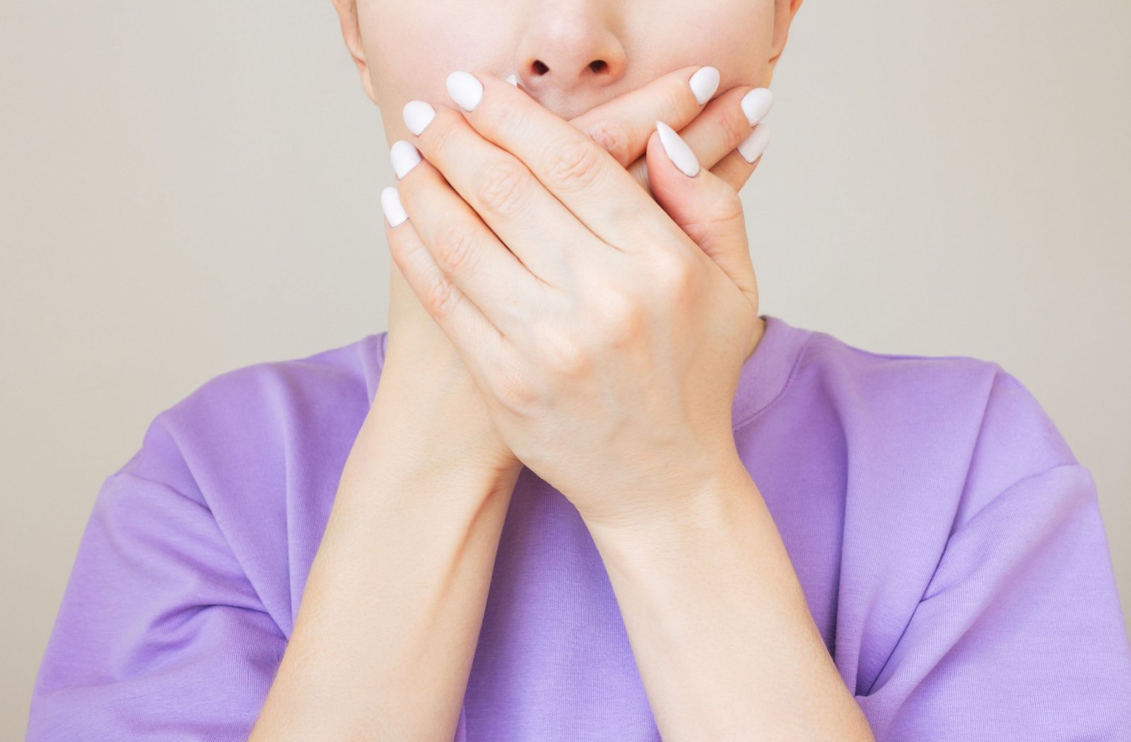 A person covers their mouth with their hands.