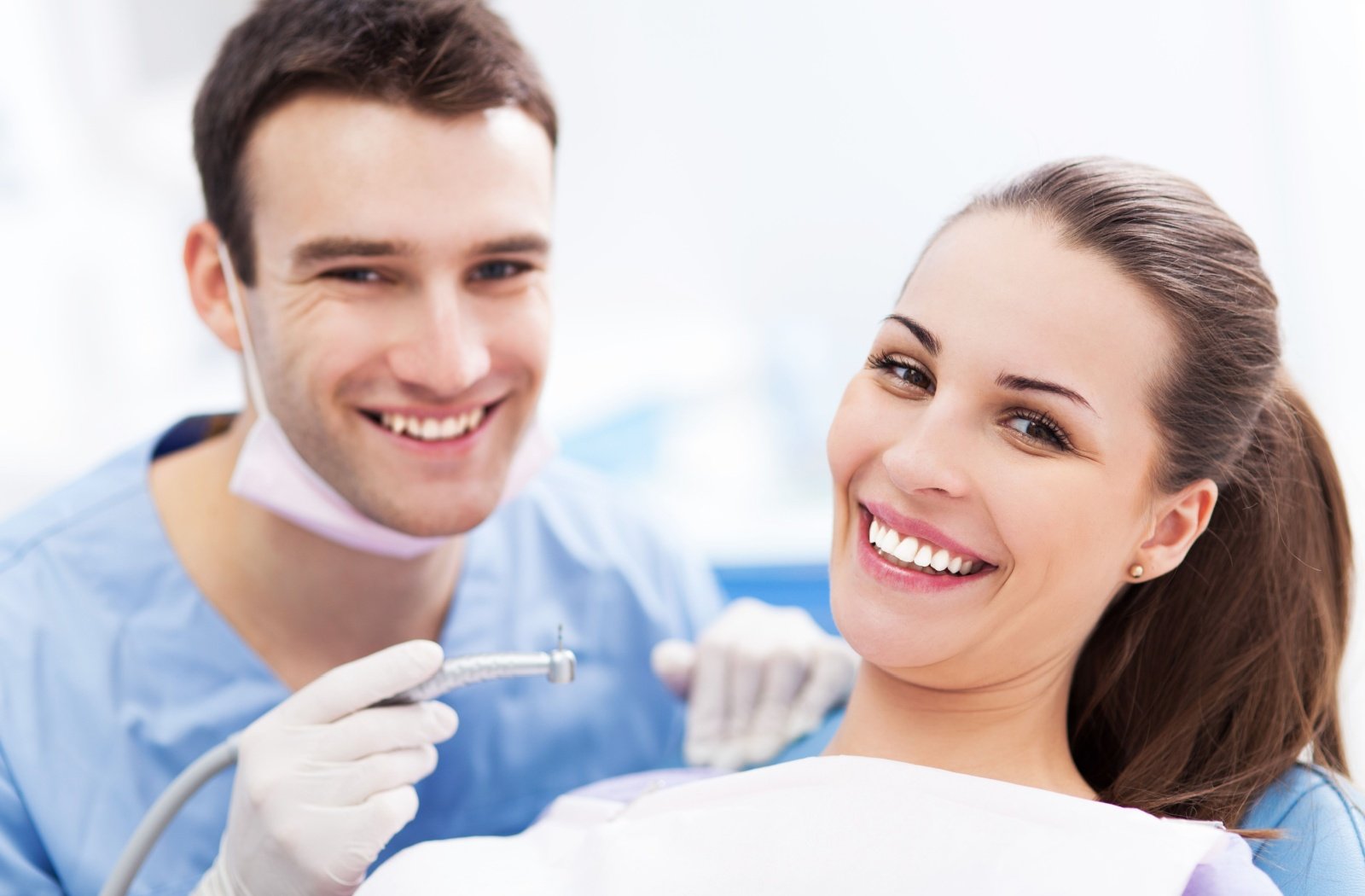 A dental hygienist and patient share a smile after a routine dental cleaning.